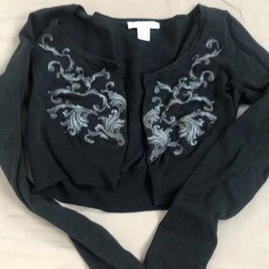 Cropped black sweater with silver appliqué